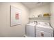 Bright laundry room featuring a new washer and dryer, and flamingo themed decorations at 1013 Gentle Swan St # 696, Henderson, NV 89011