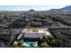 Stunning aerial view showcasing a desert home with a sparkling blue pool and covered parking at 10140 W Tropical Pkwy, Las Vegas, NV 89149