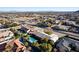 Wide aerial view showcasing a desert home with a sparkling blue pool, covered parking, and scenic neighborhood at 10140 W Tropical Pkwy, Las Vegas, NV 89149