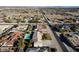 Wide aerial view showing a desert home with a sparkling blue pool, covered parking, and scenic neighborhood at 10140 W Tropical Pkwy, Las Vegas, NV 89149