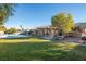 Expansive backyard featuring lush green lawn, private pool, covered patio and mature trees at 10140 W Tropical Pkwy, Las Vegas, NV 89149