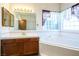 Bathroom featuring a central soaking tub and single sink vanity with mirror and lighting at 10140 W Tropical Pkwy, Las Vegas, NV 89149