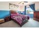 Comfortable bedroom featuring a king bed, artwork, and blue accent wall at 10140 W Tropical Pkwy, Las Vegas, NV 89149
