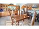 Dining area with a large table and chairs, connecting to the open kitchen with wood cabinetry at 10140 W Tropical Pkwy, Las Vegas, NV 89149