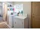 A functional laundry room includes a window, washer, and dryer at 10140 W Tropical Pkwy, Las Vegas, NV 89149