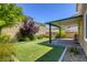The backyard features a covered patio, green artificial turf, and meticulous landscaping at 10164 Phelps Lake Ct, Las Vegas, NV 89148