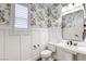 Charming powder room with floral wallpaper, white wainscoting, and modern fixtures at 10164 Phelps Lake Ct, Las Vegas, NV 89148