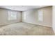 Neutral bedroom featuring neutral carpet, walls and three windows for natural light at 10164 Phelps Lake Ct, Las Vegas, NV 89148