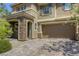 Two story home with neutral colored stucco, stone facade, and attached two car garage at 10164 Phelps Lake Ct, Las Vegas, NV 89148