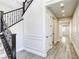 Bright hallway with wood floors, paneled walls, and a staircase with dark wood banister at 10164 Phelps Lake Ct, Las Vegas, NV 89148