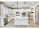 Modern white kitchen with stainless steel appliances, quartz countertops and center island at 10164 Phelps Lake Ct, Las Vegas, NV 89148