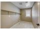 Functional laundry room featuring tile floors, built-in shelves, and a window for natural light at 10164 Phelps Lake Ct, Las Vegas, NV 89148