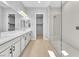 Bright bathroom featuring a double sink vanity, a large glass walk-in shower, and a walk-in closet at 11707 Hatchling Ave, Las Vegas, NV 89138