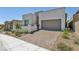 Contemporary home showcasing a well-manicured front yard with desert landscaping and neutral stucco at 11707 Hatchling Ave, Las Vegas, NV 89138