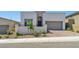 Modern two-story home featuring desert landscaping, a brick driveway, and a two-car garage at 11707 Hatchling Ave, Las Vegas, NV 89138