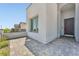 Close-up of a modern home's arched entry, featuring a neutral stucco exterior and a brick driveway at 11707 Hatchling Ave, Las Vegas, NV 89138