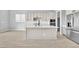 Kitchen with large island, white cabinets, stainless-steel appliances, and light wood-style flooring at 11707 Hatchling Ave, Las Vegas, NV 89138