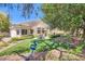 Backyard featuring artificial grass, covered patio, and lush landscaping at 1314 Rossini St, Henderson, NV 89052