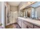 The spacious bathroom features double sinks, neutral paint, framed mirrors and glass shower enclosure at 1314 Rossini St, Henderson, NV 89052