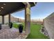 Serene backyard with artificial turf, rock landscaping, and covered patio perfect for low-maintenance living at 2246 Bird Of Prey St, Las Vegas, NV 89138
