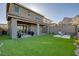 Expansive backyard with artificial turf, covered patio, lounge seating, and mountain views, perfect for entertaining at 2246 Bird Of Prey St, Las Vegas, NV 89138