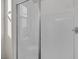 Bathroom shower with white tiling, a glass door, and a built in shelf at 2246 Bird Of Prey St, Las Vegas, NV 89138
