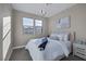 Bedroom features neutral walls, modern light fixture, dual windows, and plush carpeting at 2246 Bird Of Prey St, Las Vegas, NV 89138