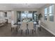 Modern dining room with sleek furniture, stylish chandelier, view of backyard and connecting kitchen area at 2246 Bird Of Prey St, Las Vegas, NV 89138