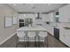 Well-lit kitchen featuring white cabinets, stainless steel appliances, and center island with barstools at 2246 Bird Of Prey St, Las Vegas, NV 89138
