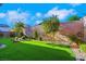 Artificial turf backyard with low maintenance landscaping, mature trees, and stone accents at 2386 Millergrove Ave, North Las Vegas, NV 89086
