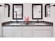 Bathroom featuring double sinks with granite countertops, modern fixtures, and framed mirrors at 2386 Millergrove Ave, North Las Vegas, NV 89086