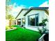 Home's exterior featuring artificial turf and low maintenance landscaping with trees and decorative rock at 2386 Millergrove Ave, North Las Vegas, NV 89086