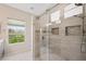 Modern bathroom featuring a tiled walk-in shower with a glass door and window at 245 Homesteader Ct, Henderson, NV 89052