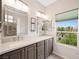 Bright bathroom with double sinks, granite countertops, and a clear view of the outdoors at 245 Homesteader Ct, Henderson, NV 89052