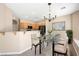 Bright dining area featuring a modern chandelier, a glass table, and access to the kitchen at 245 Homesteader Ct, Henderson, NV 89052