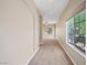 Long, carpeted hallway with natural light streaming in from the window at 245 Homesteader Ct, Henderson, NV 89052
