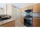 Bright kitchen area with new appliances, stylish wood-look flooring, and a view into the living room at 245 Homesteader Ct, Henderson, NV 89052