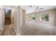Open-concept living room with plush carpeting, neutral walls, and a sliding door to the backyard at 245 Homesteader Ct, Henderson, NV 89052