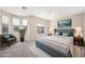 Staged main bedroom featuring a luxurious upholstered bed, neutral walls, and bright windows at 245 Homesteader Ct, Henderson, NV 89052
