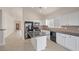 Well-lit kitchen featuring a breakfast island, black appliances, and tile flooring at 2455 Silver Blossom Ln, Henderson, NV 89052
