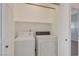 A clean and functional laundry room with washer and dryer hookups and shelf storage at 2455 Silver Blossom Ln, Henderson, NV 89052
