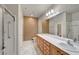 Bathroom featuring double sinks, spacious countertop, and a shower with glass doors at 2520 Eclipsing Stars Dr, Henderson, NV 89044