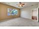 Spacious bedroom with neutral carpet, ceiling fan, and a bright window view of the community pool at 2520 Eclipsing Stars Dr, Henderson, NV 89044