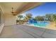 Covered patio with ceiling fan overlooking the pool and lush backyard landscaping at 2520 Eclipsing Stars Dr, Henderson, NV 89044