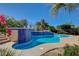 Backyard pool with blue tile accents, concrete patio, and colorful landscaping at 2520 Eclipsing Stars Dr, Henderson, NV 89044