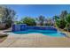 Sparkling pool featuring a tiled waterfall edge, concrete decking, and lush landscaping at 2520 Eclipsing Stars Dr, Henderson, NV 89044