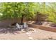 Relaxing backyard with a stone fire pit, comfortable seating, and mature trees at 2799 Alnwick Ct, Henderson, NV 89044