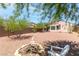 Backyard seating area surrounding a small fire pit and desert landscaping at 2799 Alnwick Ct, Henderson, NV 89044