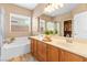 Well-lit bathroom with a double vanity, soaking tub, shower, and ample natural light at 2799 Alnwick Ct, Henderson, NV 89044