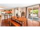 Open concept dining room featuring hardwood floors, a table with bench, and access to the kitchen and outdoor areas at 2799 Alnwick Ct, Henderson, NV 89044